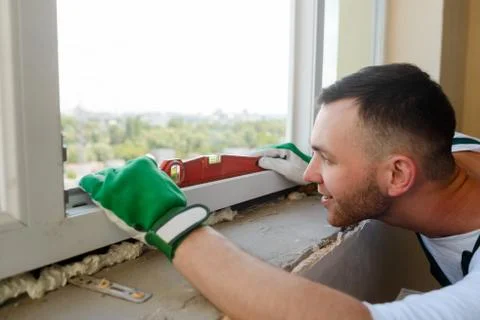 Man is using a spirit level. Construction worker is checking accuracy Stock Photos