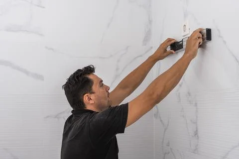 Man using a spirit level on a kitchen wall Stock Photos