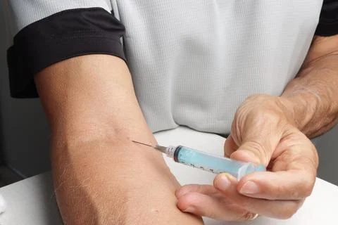 Man Using a Syringe in his Arm Stock Photos