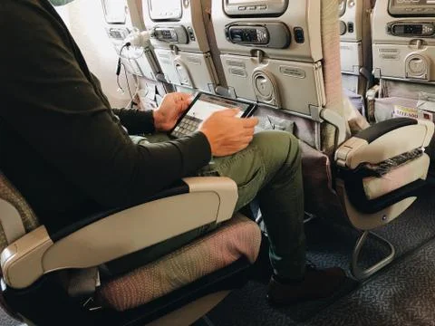 Man using tablet in the airplane Stock Photos
