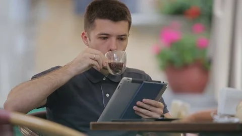 Man using Tablet and Drinking Coffee in Cafe. Stock Footage 76835560