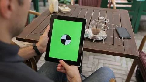Man using Tablet in Coffee Shop. Tablet with Green Screen Stock Footage 76833618