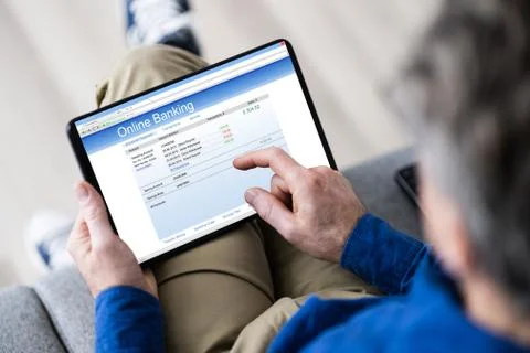Man Using Tablet Computer Checking Bank Statement Stock Photos
