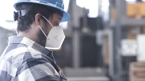 Man using a tablet computer in an industrial hall with a mask on Stock Footage 149294806