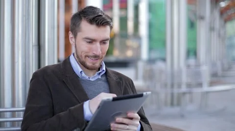 Man using tablet computer near the modern business center, skyscraper, Mall Stock Footage 68402089