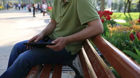 Man using tablet computer at park 5 Stock Footage 22902473