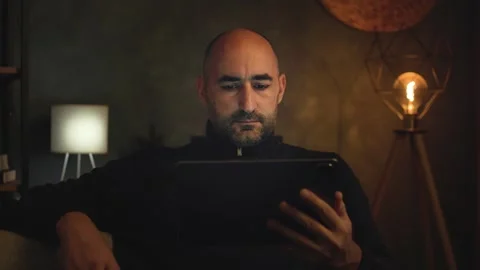 Man Using Tablet Computer Screen in Dark Room Video stock 346809883