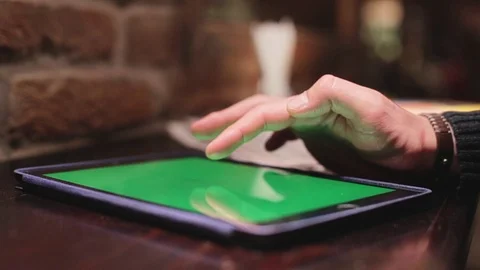 Man using tablet computer touch green screen on wooden table. Video indoor cafe Stock Footage 76562762