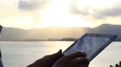 Man using tablet computer touchscreen in sunset. Stock Footage 65563976