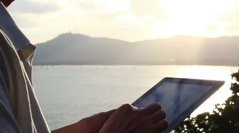 Man using tablet computer touchscreen in sunset. Stock Footage 65564279
