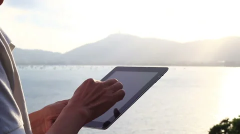 Man using tablet computer touchscreen in sunset. Stock Footage 65564441