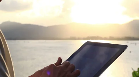 Man using tablet computer touchscreen in sunset. Stock Footage 65564561