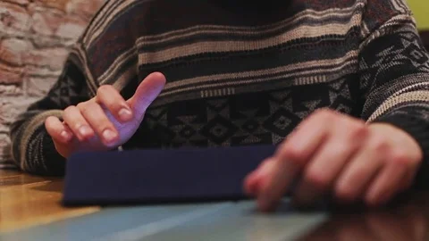 Man using tablet computer touchscreen on wooden table in cafe Stock Footage 76563641