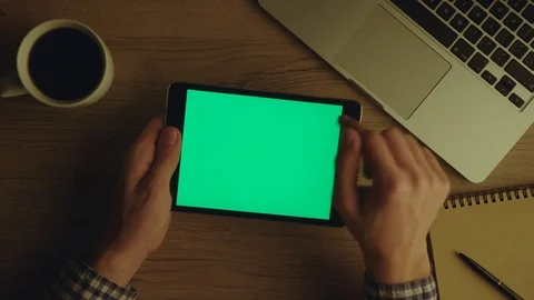 Man using tablet device with green screen at office at night. Chroma key. Table Stock Footage 75819238