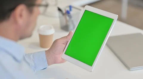 Man Using Tablet with Green Chroma Screen in Office Stock Photos