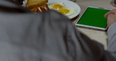 Man Using Tablet With Green Screen at Breakfast 09 Stock Footage 84130940
