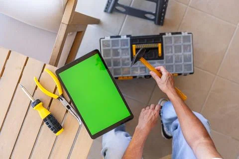 Man using tablet with green screen for home repair Stock Photos