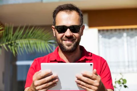 Man using tablet, looking at camera. Stock Photos