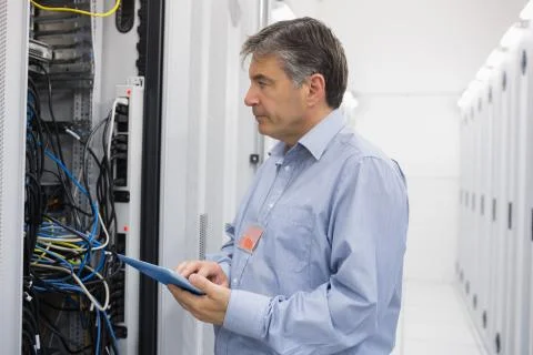 Man using tablet for maintenance on servers Stock Photos