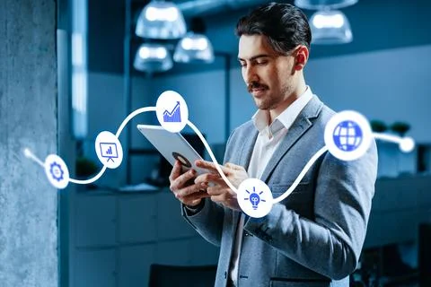 Man using a tablet to manage content in an office setting during working hour Stock Photos