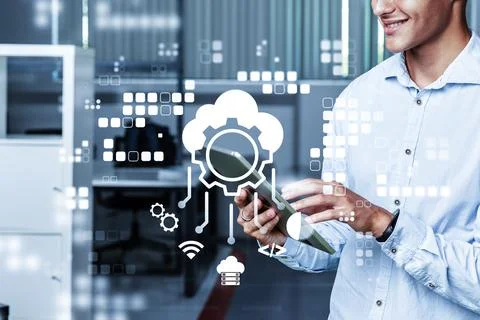 Man using tablet in office setting with digital icons for technology and Stock Photos