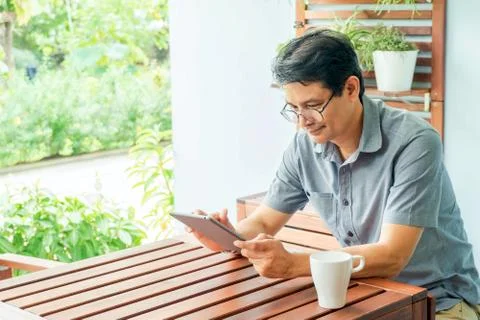 The man using tablet for online working at home for self quarantine. Stock Photos