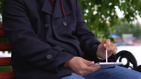 The man is using a tablet in the park. Video stock 91120724