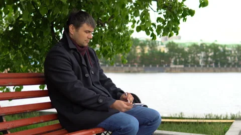 The man is using a tablet in the park. Video stock 91124073