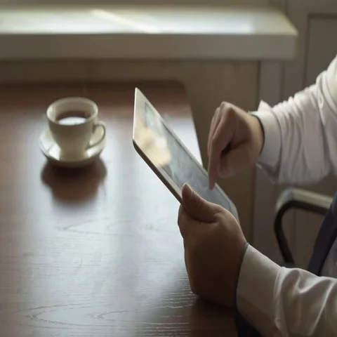 Man Using Tablet PC and Drinking Coffee in Cafe Stock Footage 69586805