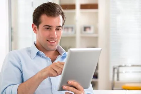 Man using tablet pc on couch at home Stock Photos