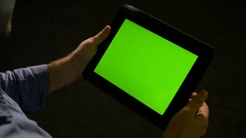 Man using tablet pc with green screen and zooming in and out on the display Vídeos de archivo 74356117