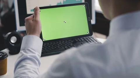 A man using a tablet PC with a green screen in front of camera. 4K Video stock 85116777