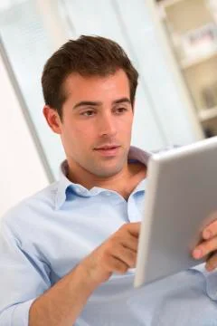 Man using tablet pc on sofa at home Foto stock