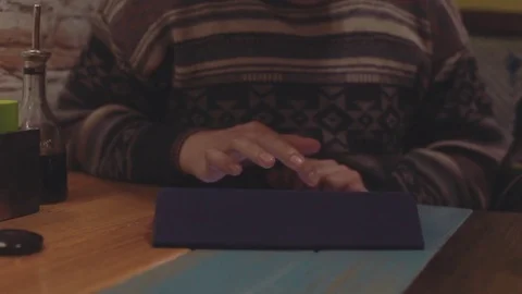 Man using tablet for shopping. Computer touch screen pad on wooden table in cafe Stock Footage 76562969