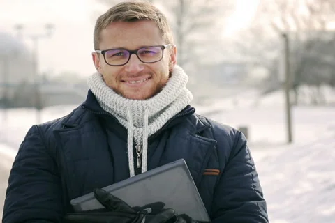 Man using tablet in the snowy park and smiling to the camera Stock-Footage 46981957