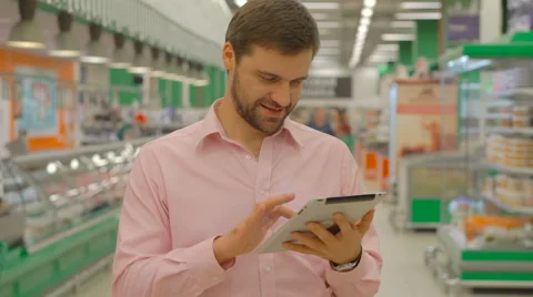 Man using tablet in supermarket store Stock Footage 63365457