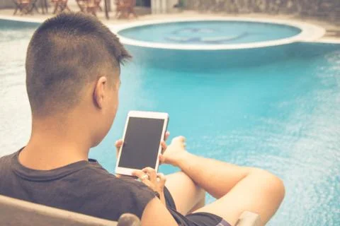 Man using tablet on swimming pool background Stock-Fotos