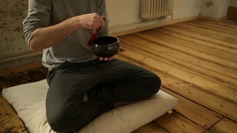 Man using Tibetan singing bowl in yoga class Stock Footage 112999410