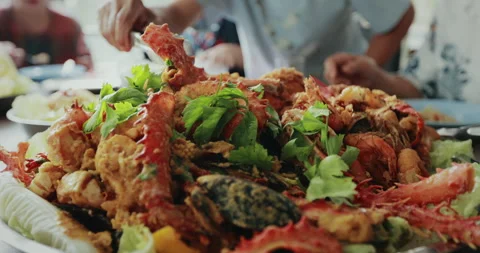 Man using tongs grab cooked alaskan crab muscles put into the plate Stock Footage 287545831