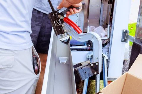 Man using tool to cutting hole in gutter at work site Stock Photos