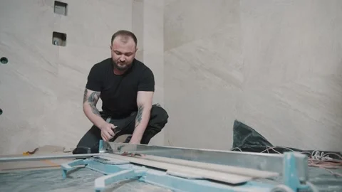 Man using tools to lay tiles on a floor for a renovation project Stock-Footage 317376414