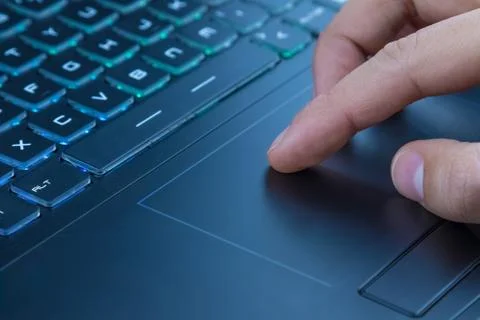 Man using touchpad on notebook keyboard with his finger Foto stock