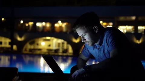 Man Using Touchscreen Laptop And Typing By Pool Late Evening, Cinematic 4K 스톡 동영상 104662042