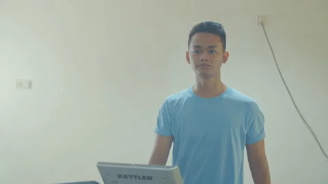 A Man Using Treadmill in Small Gym Stock Footage 162174501