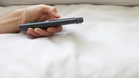Man using TV remote control while relaxing on a sofa at home Video stock 336908054