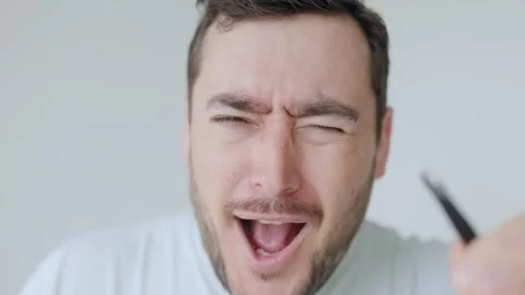Man using tweezers to remove eyebrow hairs, astonished facial reaction Stock Footage 306258222