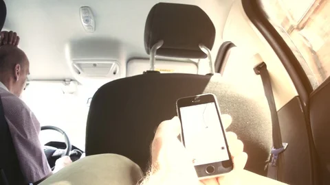 Man using Uber App inside car during ride Stock Footage 107877398