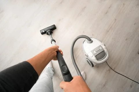 Man using a vacuum cleaner at home. Man cleaning house. House keeping concept Stock Photos