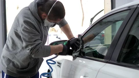 A man using vacuum hose, wipes moisture and stains from car with a special rag Stock Footage 230928188
