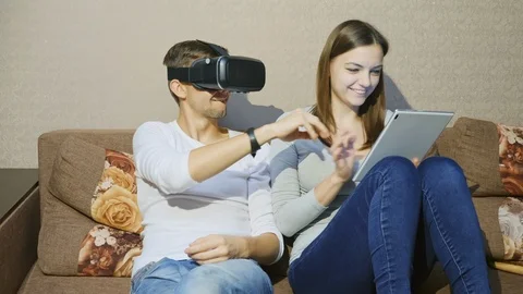 Man using virtual reality device while woman typing on digital tablet Stock Footage 86192530